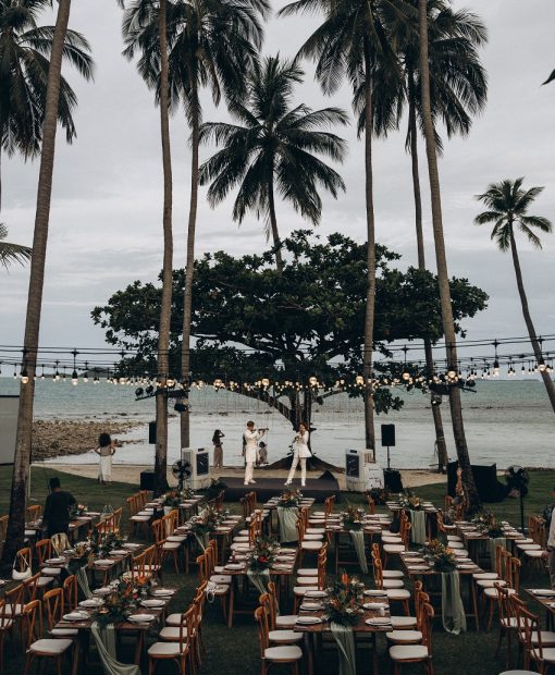 Seaside gala dinner in Phuket with tropical setup and live performance under palm trees