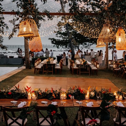 Oceanfront birthday dinner in Phuket with candlelit long table and floral decor