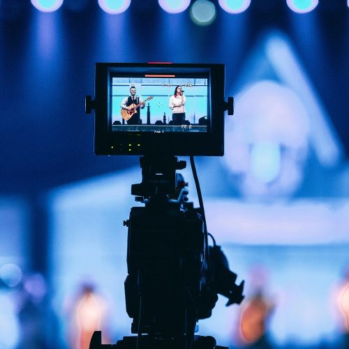 Event videographer filming elegant corporate gala in Phuket with professional equipment background